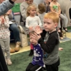 A young boy claps to storytime in the library story room.