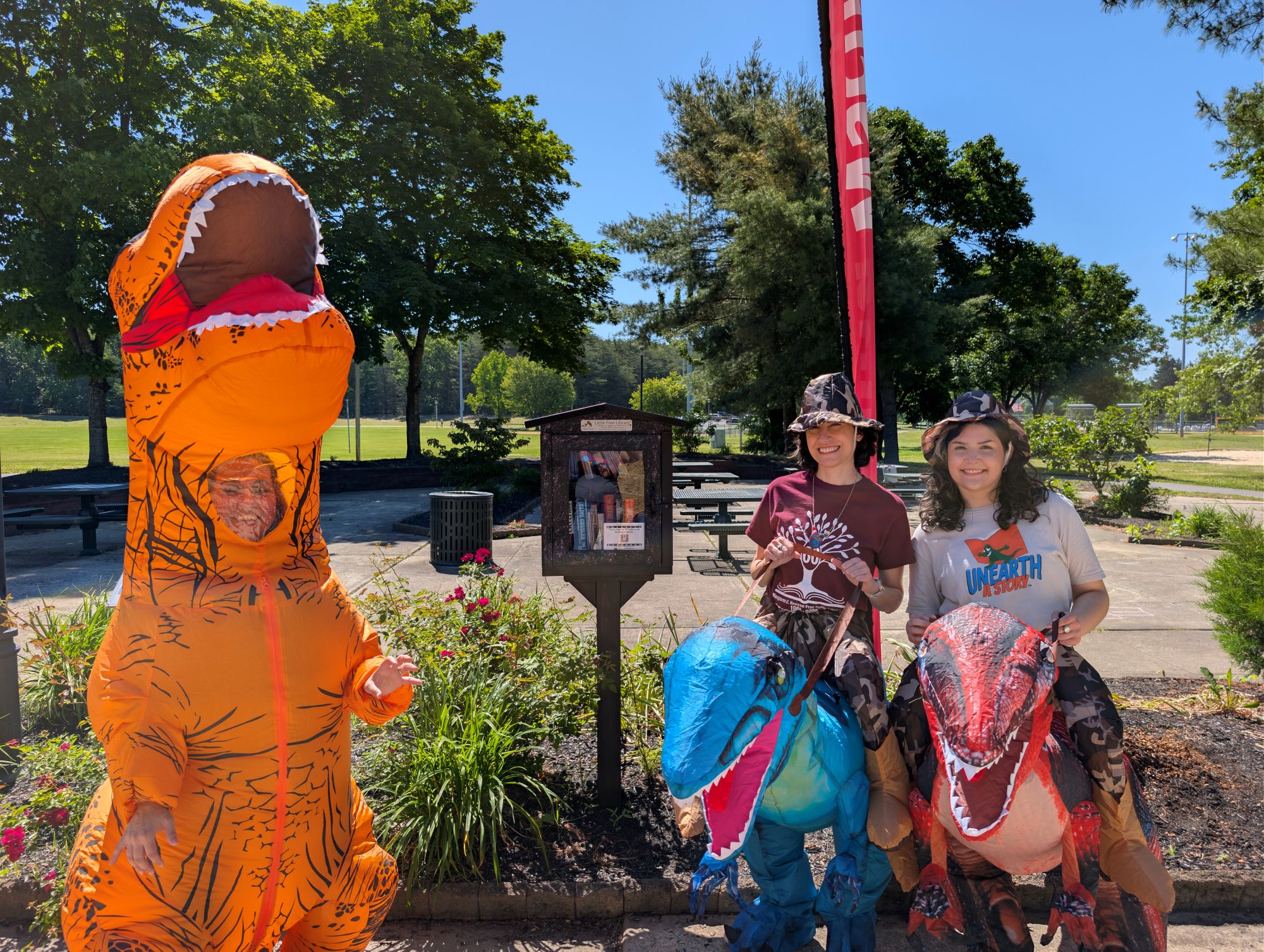 Rebeccasaurus, Stephasaurus, and Sarasaurus in front of the Little Free Library at the Washington Lake Park