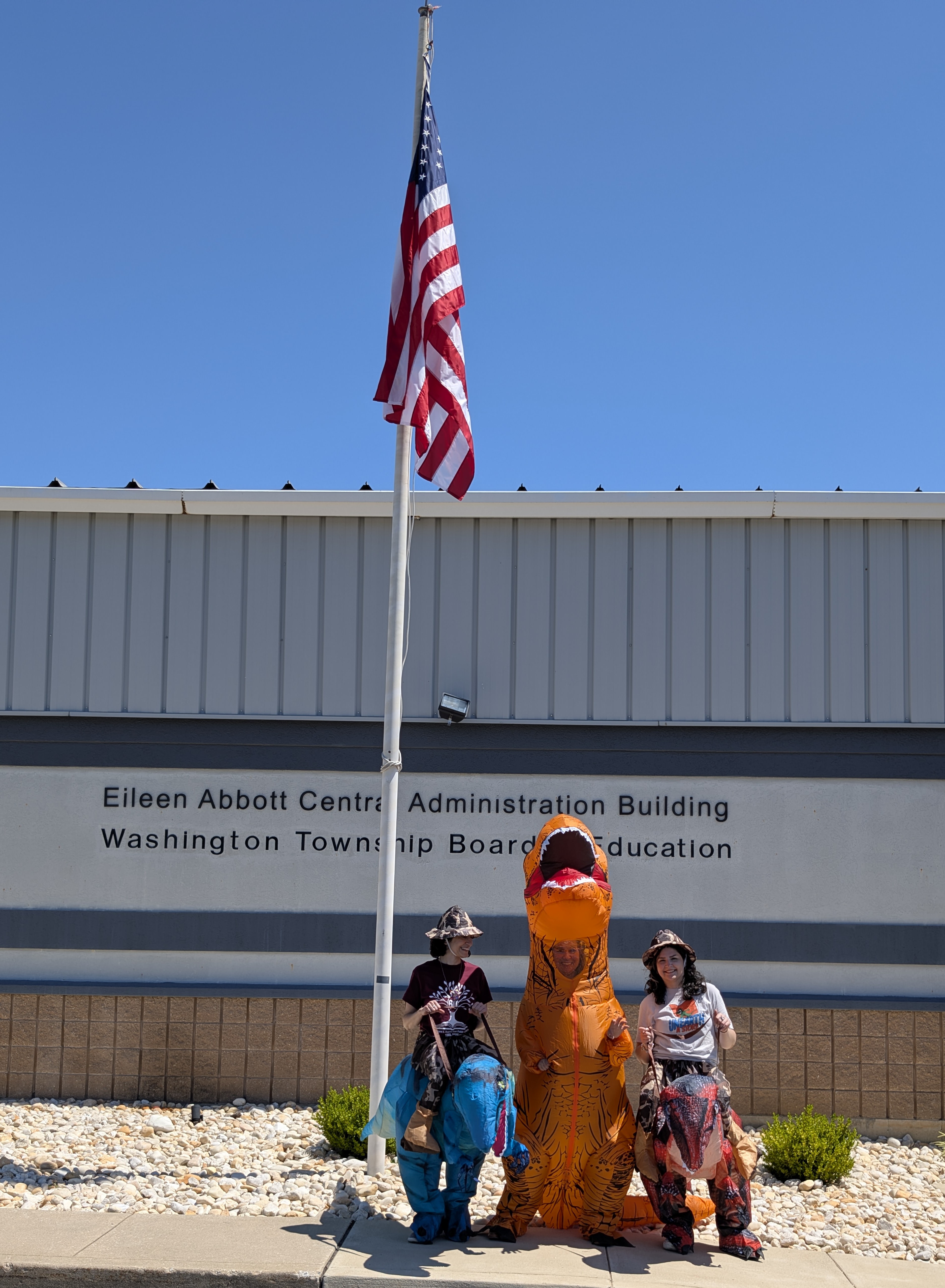 Rebeccasaurus, Stephasaurus, and Sarasaurus in front of The Eileen Abbott Central Admin Building