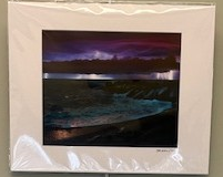 A thunderstorm seen from a distant shore. The sky is lit up in purple as a lightning bolt erupts from the bottom of a long black cloud. We can see the sky below and above this dark cloud.