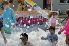 Mr. Foamtastic blasts foam into a crowd of patrons from a mounted foam cannon