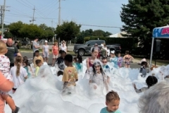 Children play in foam in the library parking lot