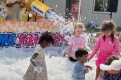 Mr. Foamtastic blasts foam into a crowd of patrons from a mounted foam cannon