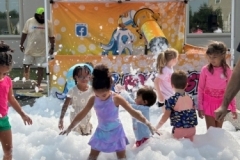 Children play in foam in the library parking lot