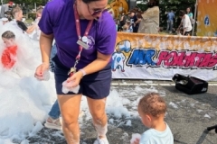 Youth Services Librarian Sara Figueroa presents some foam to a young child