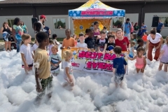 Children play in foam in the library parking lot