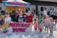 Children play in foam in the library parking lot
