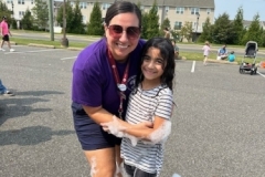 Youth Services Librarian Sara Figueroa poses for a photo with a child