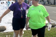 Youth Services Librarian Sara Figueroa places foam on the head of Library Director Sheila Mikkelson