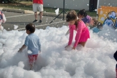 Children play in foam in the library parking lot